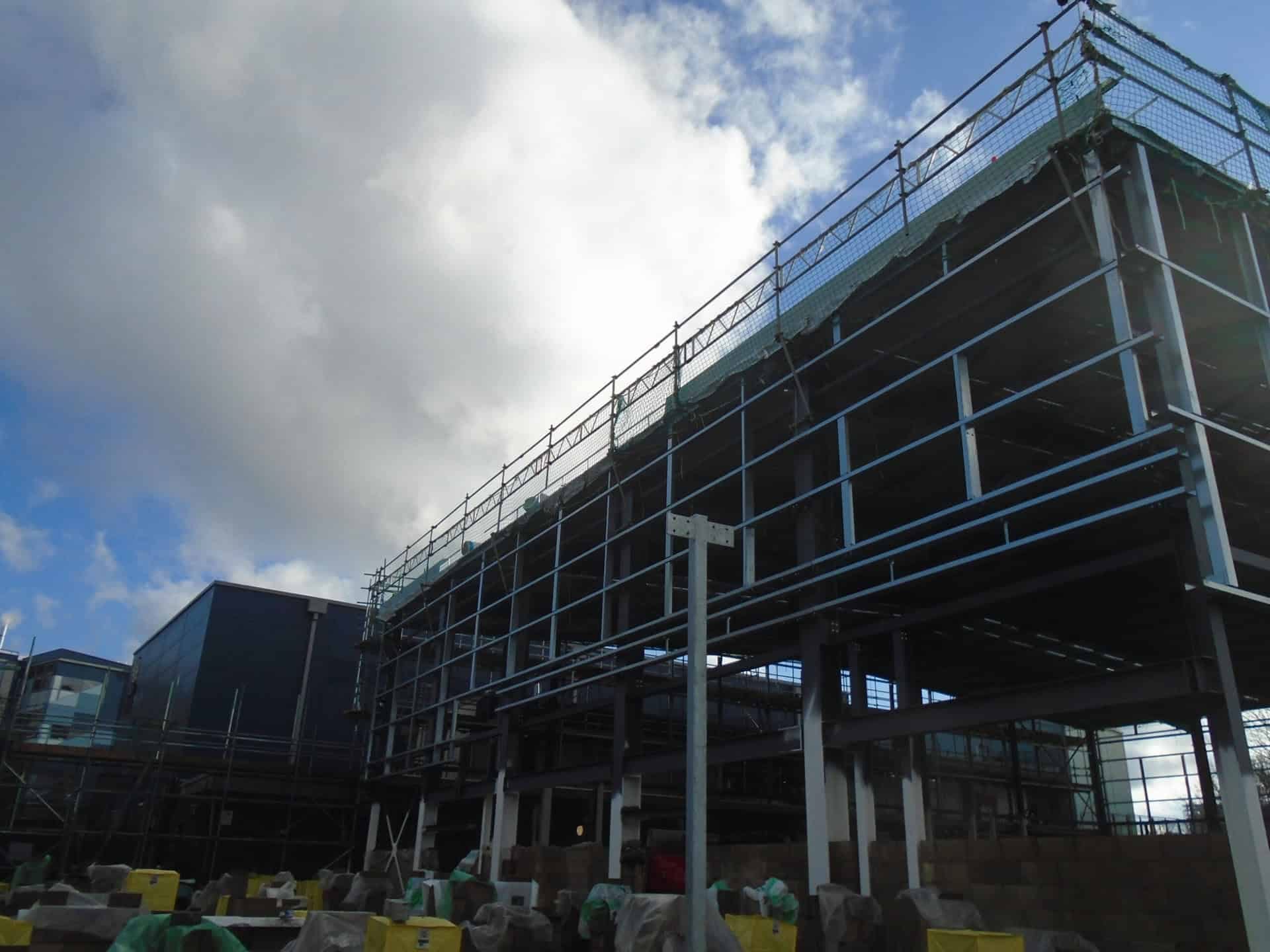 Steel-framed building with scaffold and edge protection