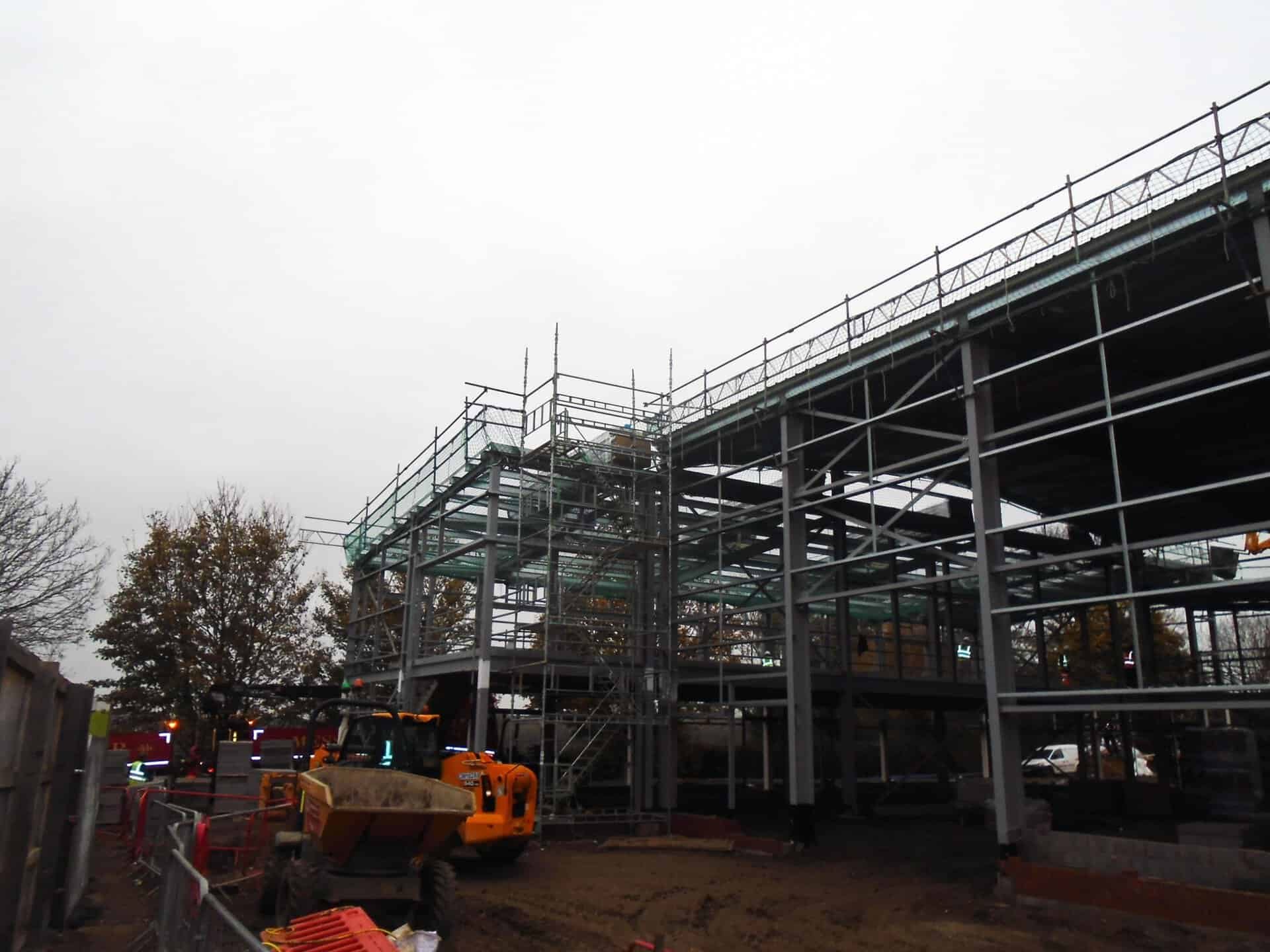 Steel-framed building under construction with scaffold and access
