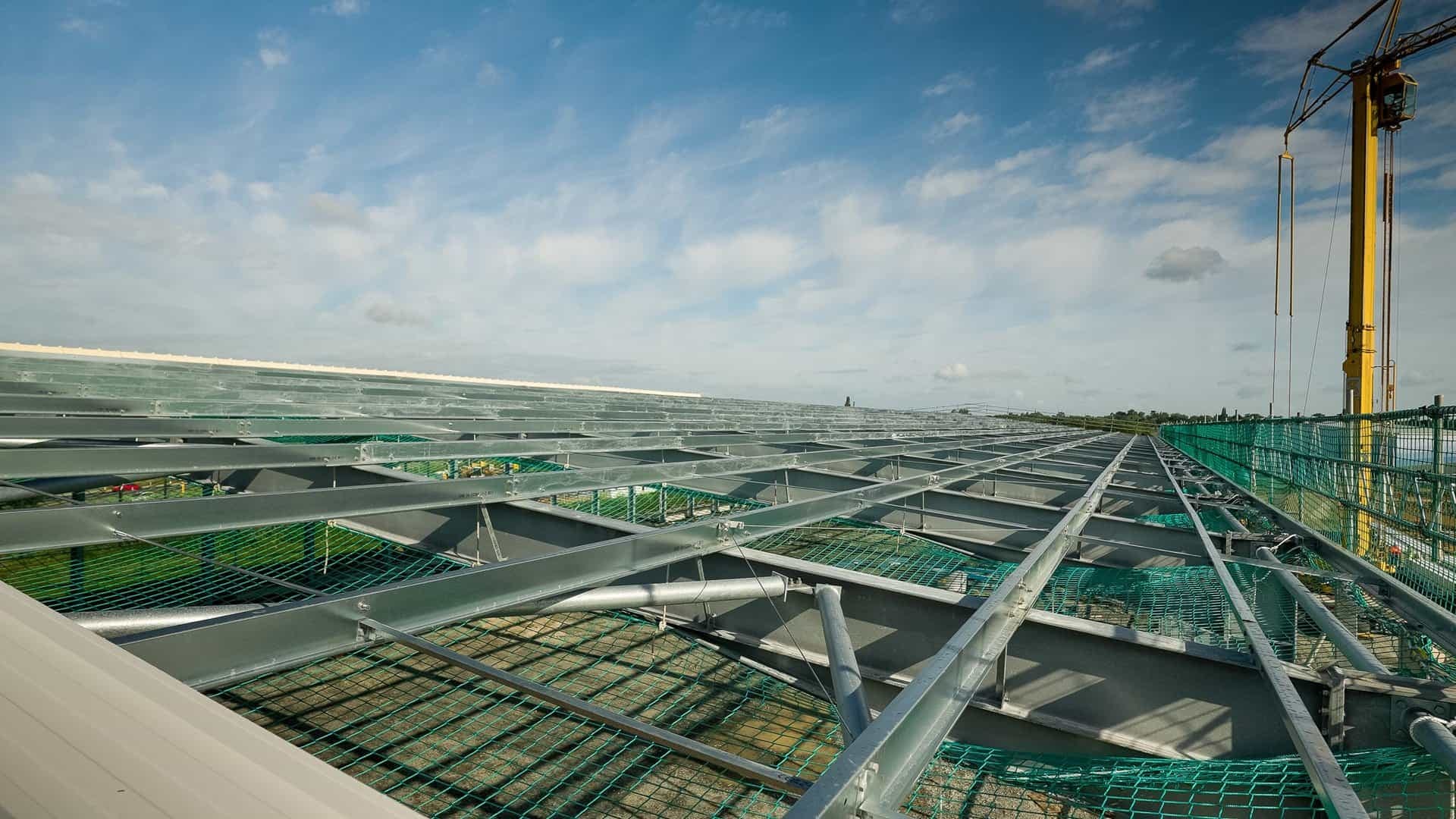 Safety netting rigged across the roof steelwork of a large building